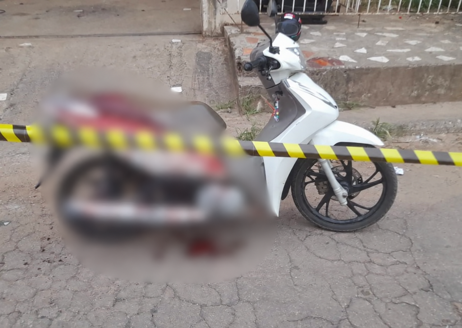 Motocicleta e área isolada após ataque no Taquari; imagem com desfoque preservado